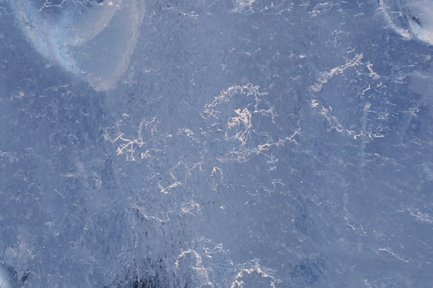 Textuur van ijs in de winter. Stukken bevroren water op een straat in de winter. De textuur en textuur van het bevroren water in de winter en buitenshuis.