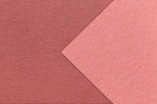 Textuur van kastanjebruin papier achtergrond half twee kleuren met roze pijl macro Structuur van dicht ambachtelijk roze karton