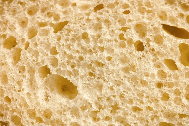 Textuur van wit brood als een close-up achtergrond achtergrond van ruw gevlekt getextureerd oppervlak plakje brood of sandwichdeeg van natuurlijk biologisch voedsel met gaten bovenaanzicht