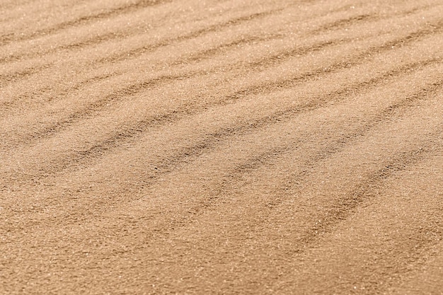 Textuur van zand met golven in de woestijn als achtergrond, close-up