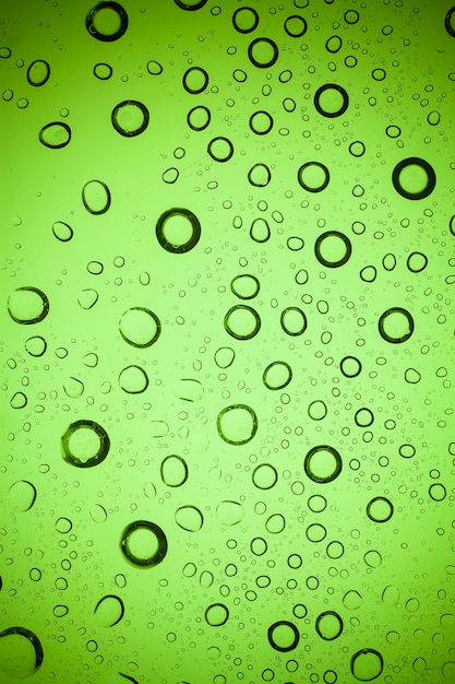 Textuur waterdruppels op groen glas.