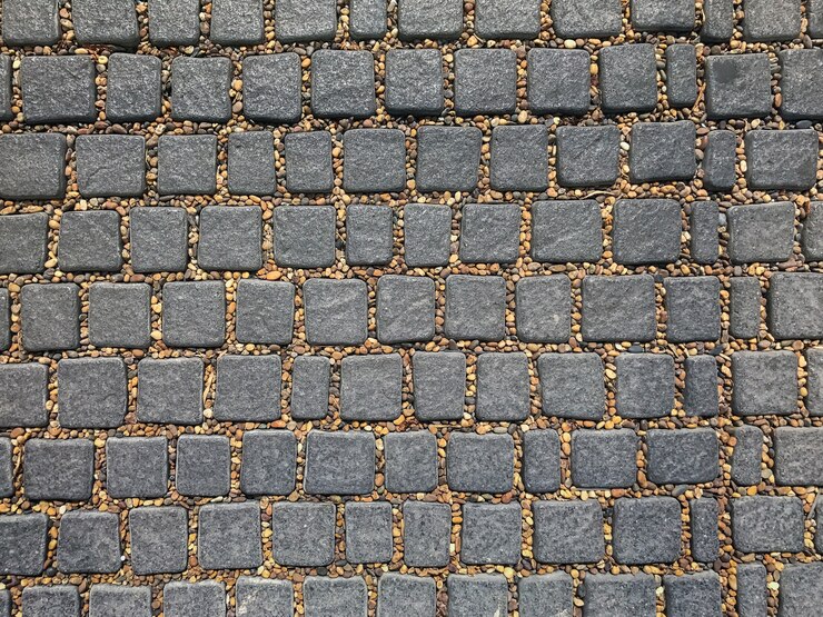 textuurachtergrond van grijze cobble steen en bruine kiezelstenen tussen kuil
