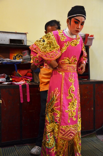 2011年3月13日にタイのバンコクでショーのために現在の伝統的な中国の古典的なオペラを演じるために顔に絵を描き、アンティークの演技服を着ている中国系のタイの演技者