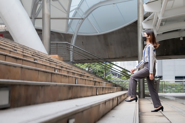 Photo thai asian businesswoman standing and walking up stairs