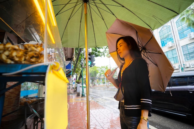 Тайские азиатские девушки покупают уличную еду в Бангкоке.