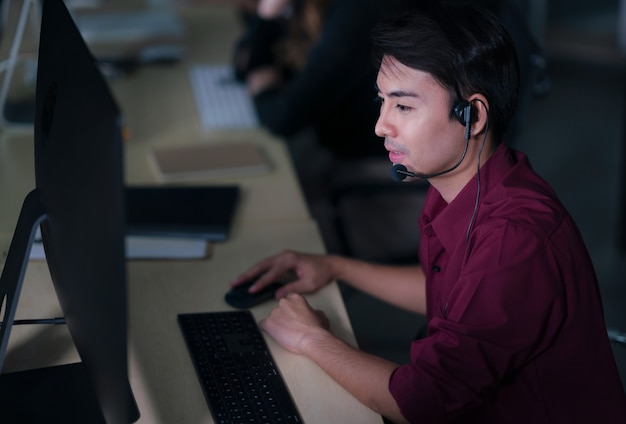 Thai Asian man customer services care operators working night shift in call center