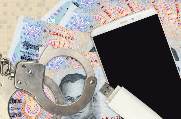 Thai Baht bills and smartphone with police handcuffs