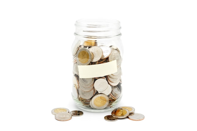 Thai Baht coins in a glass jar with blank label isolated on white background Financial concept