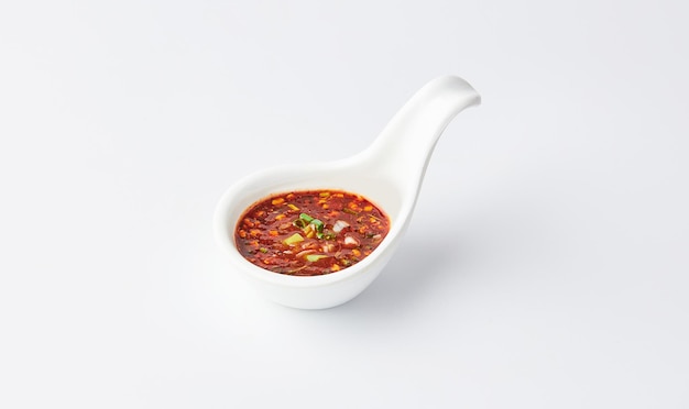 Thai chili saus Nam jim jaew geserveerd op witte lepel beker geïsoleerd op een witte achtergrond