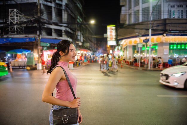 Photo thai-chinese tourists stroll around and sample street food at yaowarat road, chinatown, bangkok