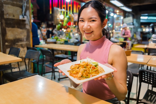 Thai-Chinese tourists stroll around and sample street food at Yaowarat Road, Chinatown, Bangkok