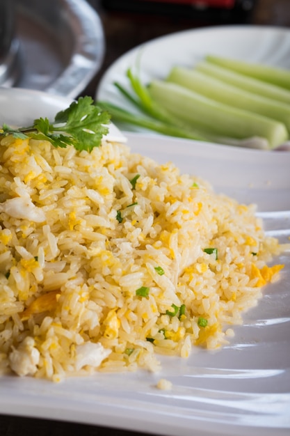 Thai crab fried rice on white dish with cucumbers