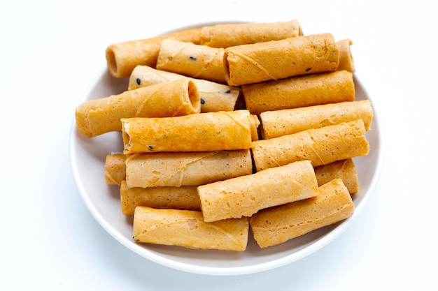 Thai crispy coconut rolls on white background.