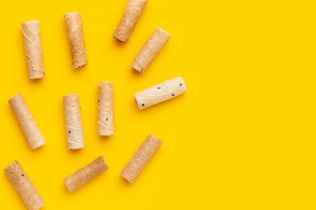 Thai crispy coconut rolls on yellow background