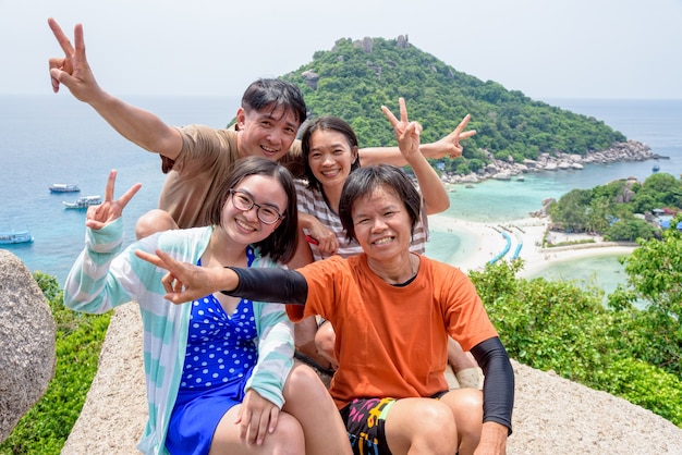 タイの家族旅行者は、ナンユアン島の上で楽しくポーズをとっています。高い視点と美しい自然の風景は、タイ湾、スラートターニー、タイの有名なアトラクションです。