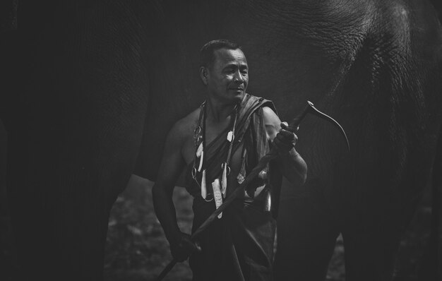 Thai farmer walking with the elephant in the jungle