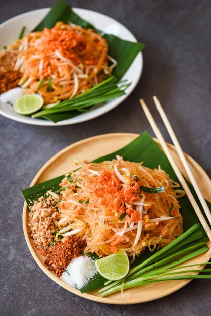 タイ料理揚げ麺タイ風エビ豆もやしとガーニッシュピーナッツチリパウダーシュガーレモンライム、食卓料理で提供されるプレート上の炒め麺パッタイ-上面図