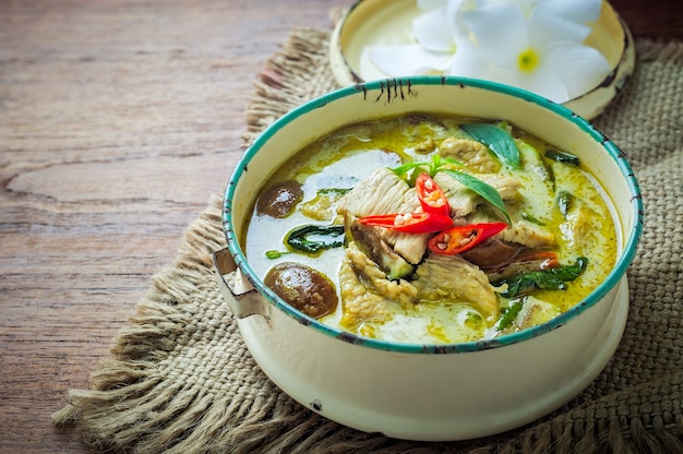 Photo thai food green curry chicken on wooden background.