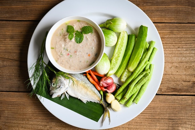 Thai food mackerel cooking mackerel fish for cooked with chili shallot garlic green brinjal cucumber fresh vegetables on white plate fish meal