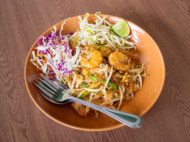 Thai fried noodles met garnalen en groenten, pad thai op een houten tafel