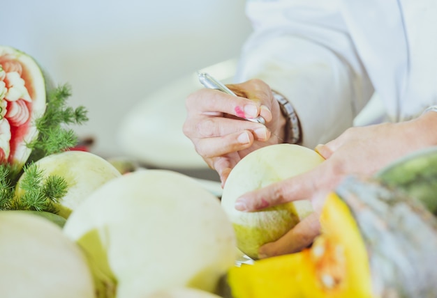 Foto frutta thailandese che intaglia con mano, verdura e frutta intagliata