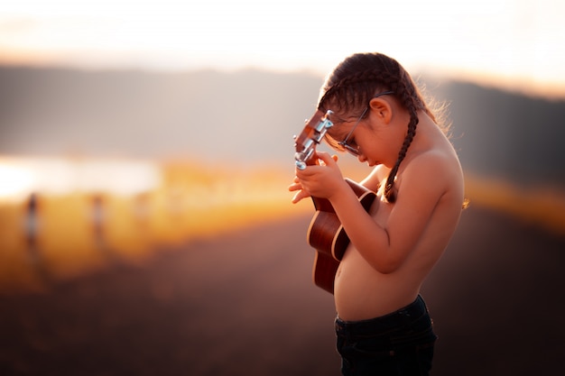 thai girl playing the ukulele with happy.