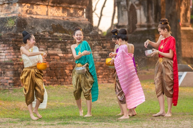 タイの女の子とラオスの女の子が祭りの間に水を跳ねるソンクラーンの祭典