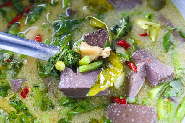 Foto zuppa di curry verde thailandese con carne di maiale e erbe in pentola calda