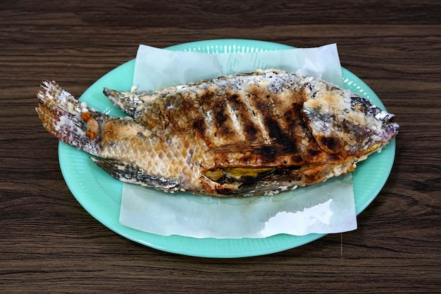 木製の背景にタイの焼き魚のレシピ