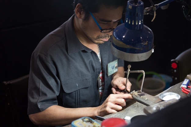 Thai jeweler making fine jewelry in a workshop