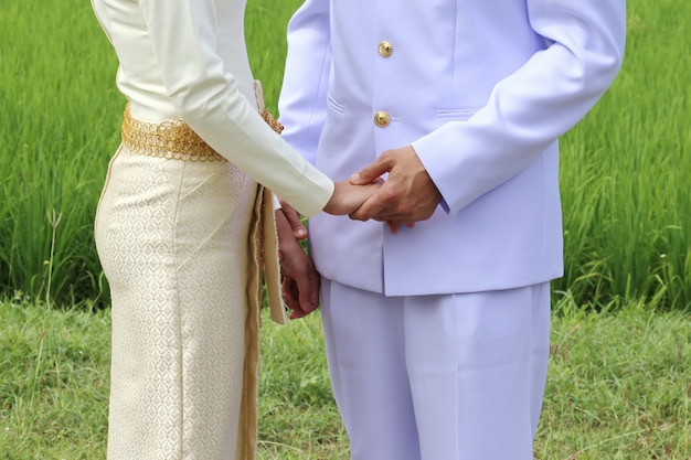 タイの恋人は結婚式のための女性の手を握る