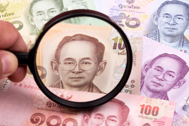 Thai money in a magnifying glass a business background