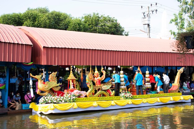 Thai people foreign traveler travel visit and join tradition merit ritual and praying offering alms giving to monk procession on boat in canal at Wat Sai Yai on November 8 2022 in Nonthaburi Thailand