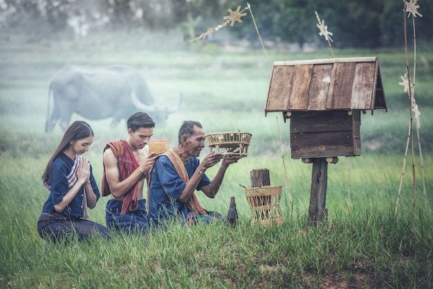 Thai people making offerings on a field