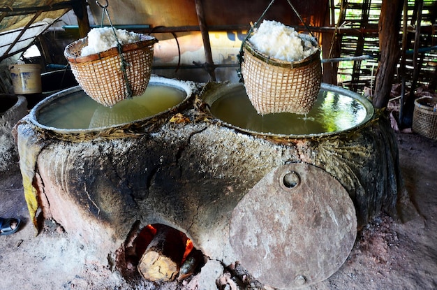 I thailandesi che mettono legna da ardere nella vecchia stufa per fare salgemma conoscenza indigena di bo kluea nella città di nan al mattino al villaggio di ban bo kluea il 30 aprile 2011 a nan thailandia