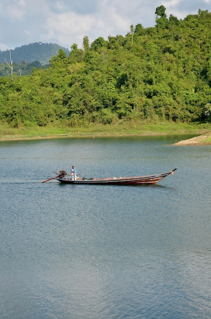 タイの人々は、タイのスラタニ州のカオソック国立公園にあるラチャプラパのチューラン湖またはラジャプラバダム貯水池を行き来するために整備されたロングテールボートを航行します。