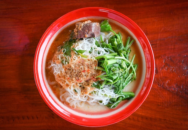 Thai rice noodle or rice vermicelli noodle and curry soup sauce\
on plate with vegetable yardlong thai style food delicious