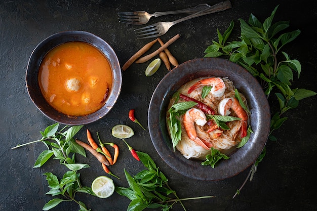 Фото Тайская рисовая лапша в соусе карри из креветок с ингредиентом на деревянном столе