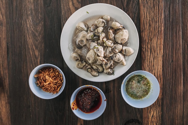 Thai seafood Fresh Oyster with three sauces served on wooden table