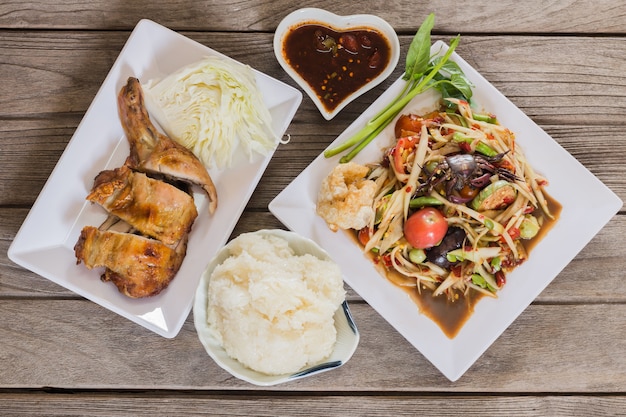 Photo thai spicy papaya salad serve with vegetables baked chicken