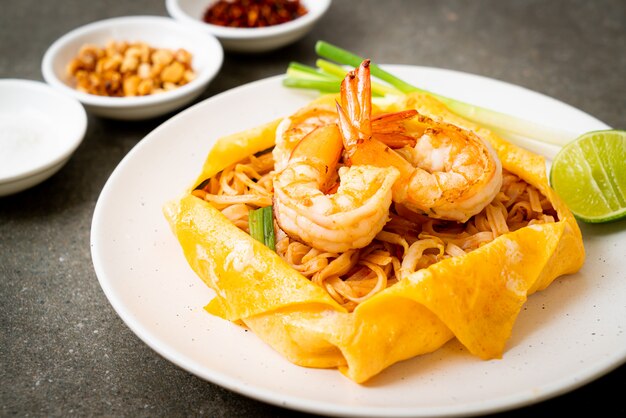 Thai stir fried noodles with shrimps and egg wrap (Pad Thai)