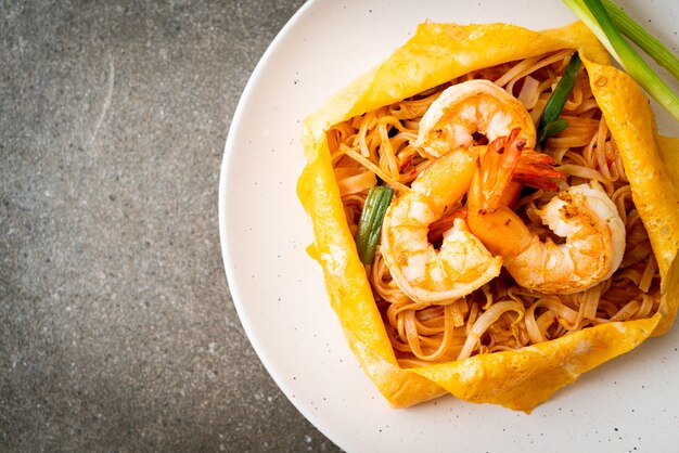 Thai stir fried noodles with shrimps and egg wrap (Pad Thai)