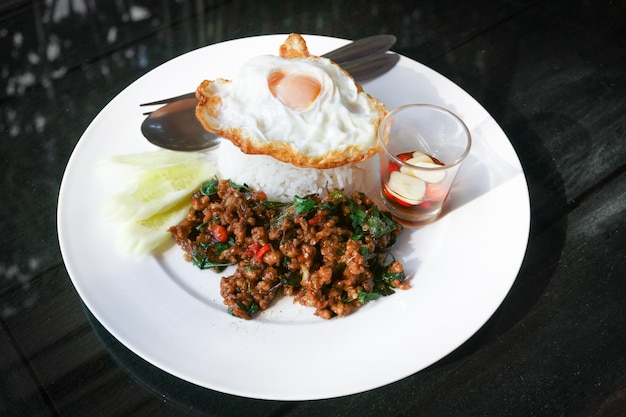 Thai stirfried pork andfried egg and basil served with riceFried Basil with Pork Chop