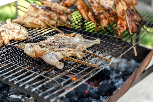 Thai Street Food: Charcoal Grilled roast Chickens on the stove half cut oil tank.