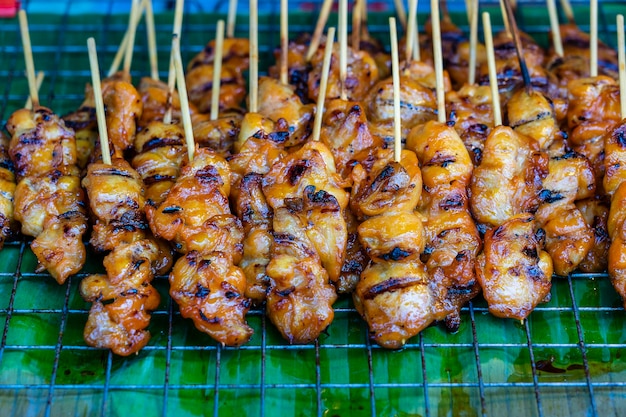 Thai street vendor sells grilled chicken meat at street food\
market thailand close up