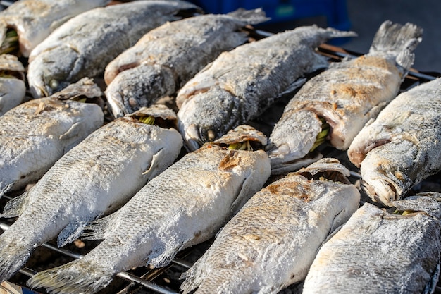 Thai street vendor sells grilled fish at street food market in island Koh Phangan, Thailand. Close up