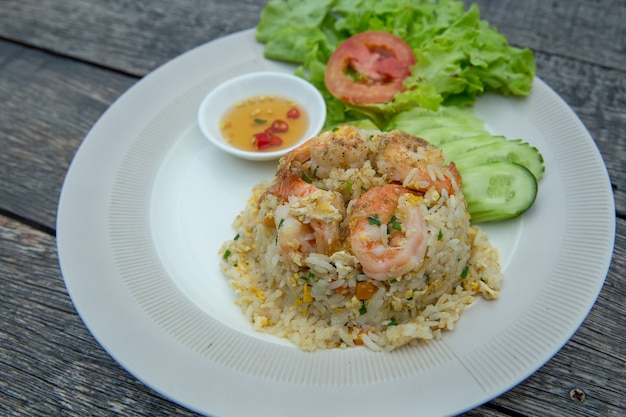 Жареный рис по-тайски с креветками или Khao Pad Goong на белой тарелке.