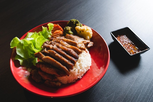 저녁 또는 점심 메인 요리로 쌀과 야채 식사 고기를 곁들인 태국식 돼지고기 구이