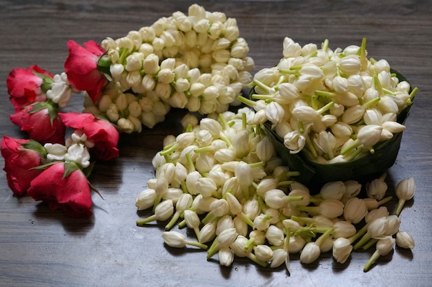 Thai style of jasmine garland and fresh jasmine flowers on wooden background