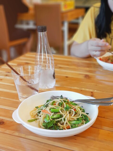 Thai style spaghetti with spices on wooden table in restaurant - vegetarian food